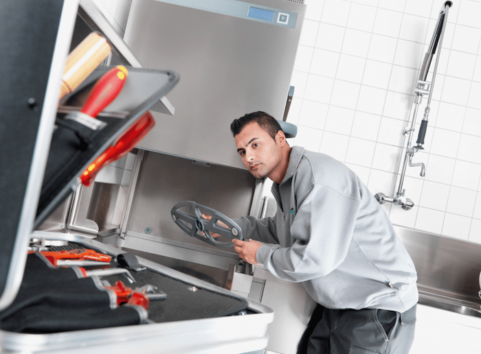 An engineer repairing kitchen equipment