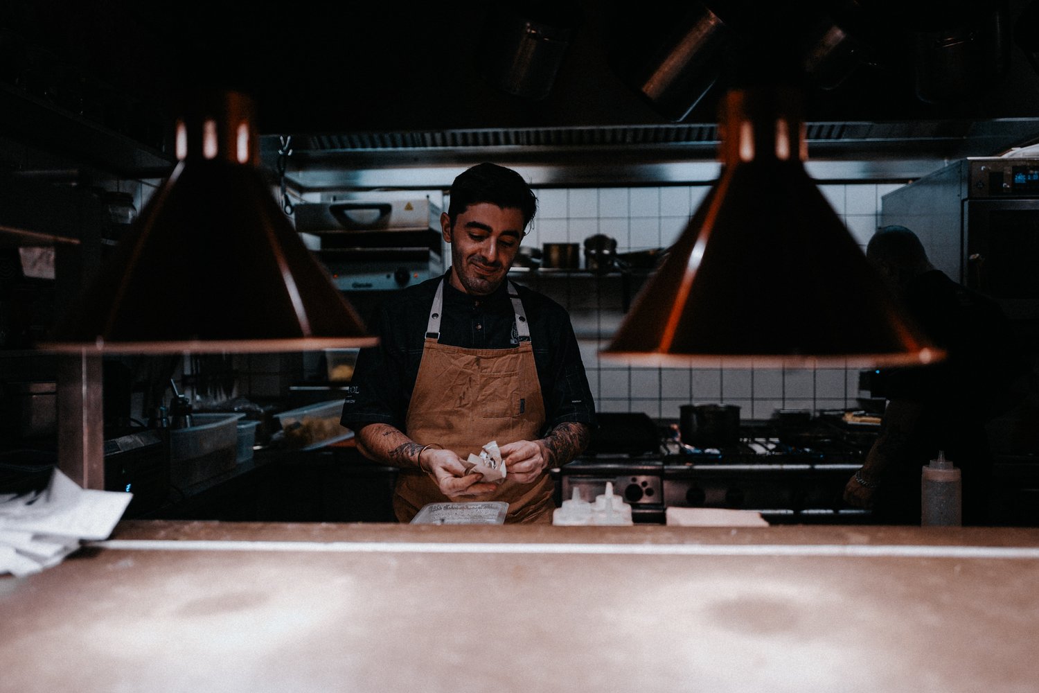 A restaurant kitchen with chef preparing food